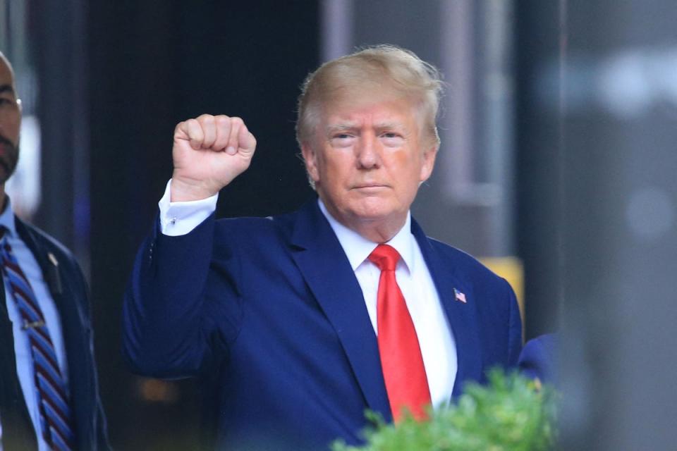 El expresidente de Estados Unidos, Donald Trump, levanta el puño mientras camina hacia un vehículo fuera de la Torre Trump en Nueva York el 10 de agosto de 2022 (AFP via Getty Images)