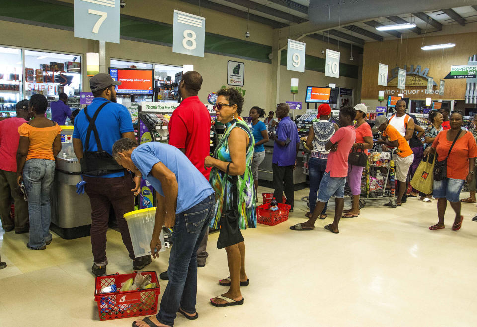 Residents stand in line at a grocery store as they prepare for the arrival of Tropical Storm Dorian, in Bridgetown, Barbados, Monday, Aug. 26, 2019. Much of the eastern Caribbean island of Barbados shut down on Monday as Dorian approached the region and gathered strength, threatening to turn into a small hurricane that forecasters said could affect the northern Windward islands and Puerto Rico in upcoming days. (AP Photo/Chris Brandis)