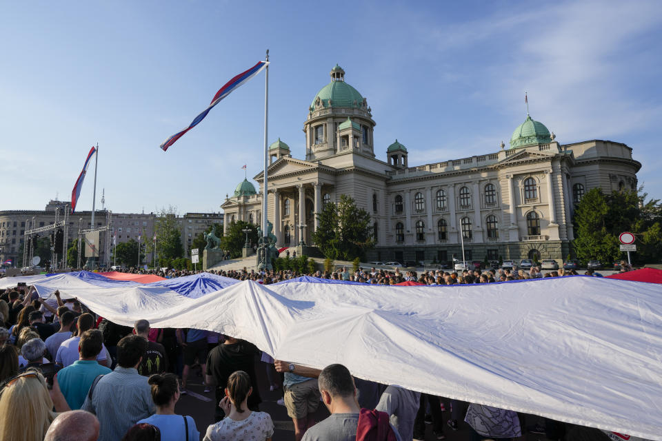 People hold a Serbian flag during a protest against violence in Belgrade, Serbia, Saturday, June 3, 2023. Tens of thousands of people rallied in Serbia's capital on Saturday in protest pf the government's handling of a crisis after two mass shootings in the Balkan country. ( (AP Photo/Darko Vojinovic)