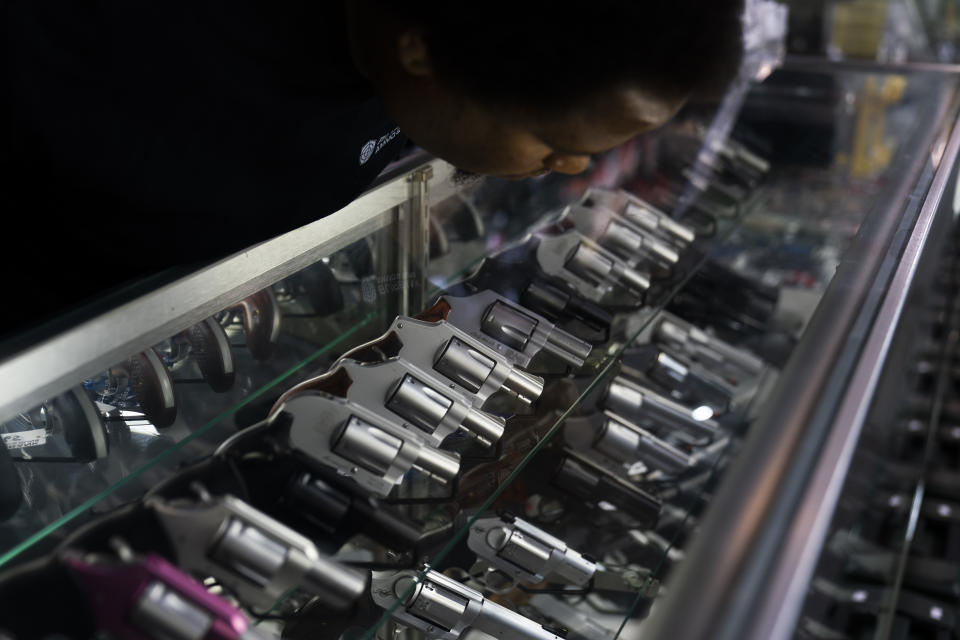 FILE - Sales associate Elsworth Andrews arranges guns on display at Burbank Ammo & Guns in Burbank, Calif., Thursday, June 23, 2022. California lawmakers for the second year were rejecting a new tax on gun sales, Wednesday, Aug. 31, 2022. The bill fell seven votes short of the supermajority it needed in the state Senate in an initial vote. (AP Photo/Jae C. Hong, File)