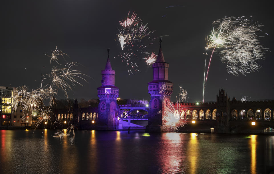 New Year's Eve fireworks light up the night sky at the turn of the year above the Oberbaumbrucke bridge in Berlin, Sunday, Jan. 1, 2023. (Paul Zinken/dpa via AP)