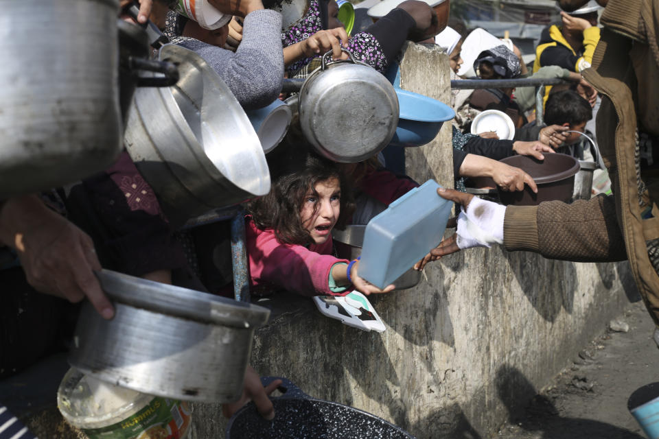 Palestinos hacen fila para conseguir comida durante la ofensiva aérea y terrestre en la Franja de Gaza, en Rafah, el martes 9 de enero de 2024. (AP Foto/Hatem Ali)