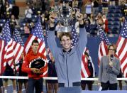 Rafael Nadal of Spain raises his trophy after defeating Novak Djokovic of Serbia (L) in their men's final match at the U.S. Open tennis championships in New York, September 9, 2013.