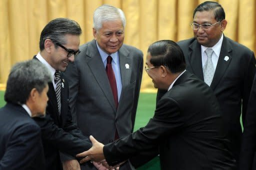 Cambodian Prime Minister Hun Sen (2nd R) shakes hands with Indonesia's Foreign Minister Marty Natalegawa (2nd L) as Philippine's Foreign Secretary Albert Rosario (C) and Myanmar's Foreign Minister Wunna Maung Lwin (R) look on during the opening ceremony of the 45th Association of Southeast Asian Nations (ASEAN) Foreign Ministers' Meeting (AMM) at the Peace Palace in Phnom Penh, on July 9