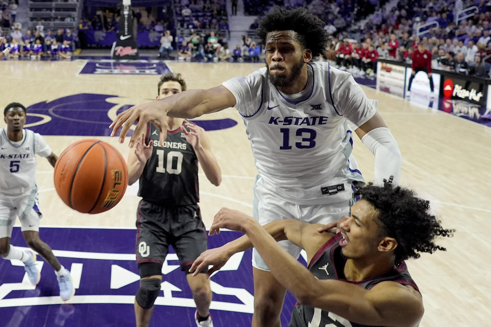 Kansas State forward Will McNair Jr. (13) blocks a shot by Oklahoma guard Milos Uzan, bottom right, during the first half of an NCAA college basketball game Tuesday, Jan. 30, 2024, in Manhattan, Kan. (AP Photo/Charlie Riedel)