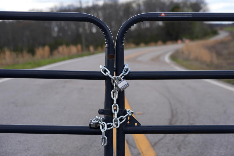 A locked gate on a closed road near the site of a planned Rivian electric truck plant is shown Thursday, March 7, 2024, in Rutledge,Ga. Rivian says it's pausing construction of the $5 billion manufacturing plant in Georgia. (AP Photo/John Bazemore)
