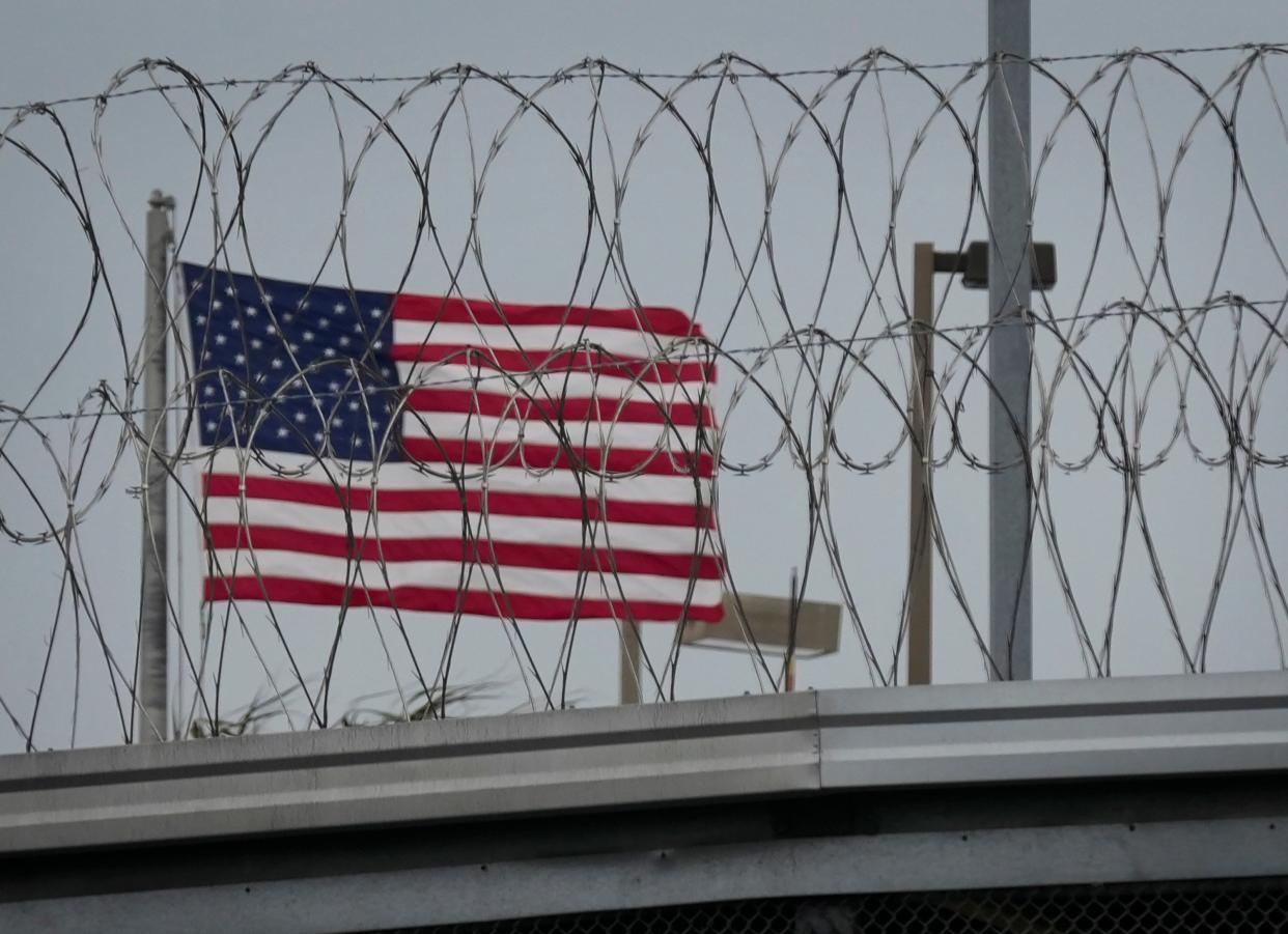 The United States flag flies behind concertina wire at the Gateway International Bridge in Brownsville, Wednesday February 28. (Credit: Jay Janner/American-Statesman)