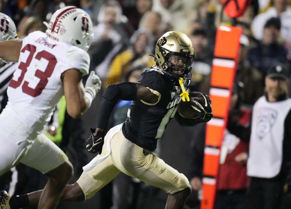 Colorado wide receiver Travis Hunter, right, runs past Stanford safety Alaka'i Gilman.