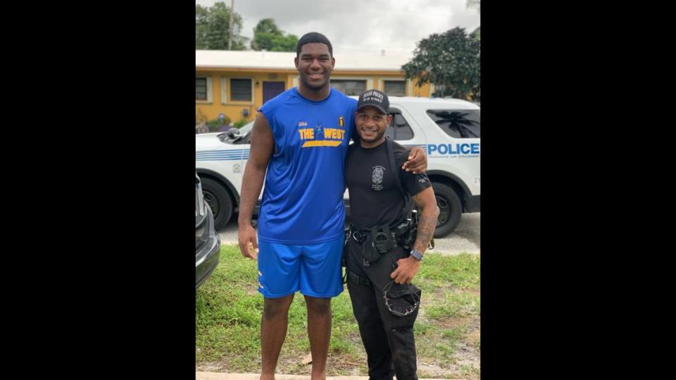 Michael Marshall, 17, left, and Miami Police Officer Raymon Washington, pose for a photo outside the teen’s Miami Gardens home.