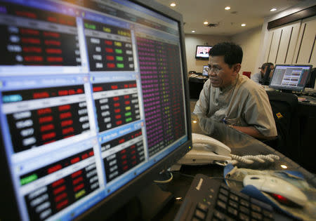 An Indonesian broker monitors share price at Bank Mandiri Sekuritas trading floor in Jakarta August 19, 2011. REUTERS/Supri/Files