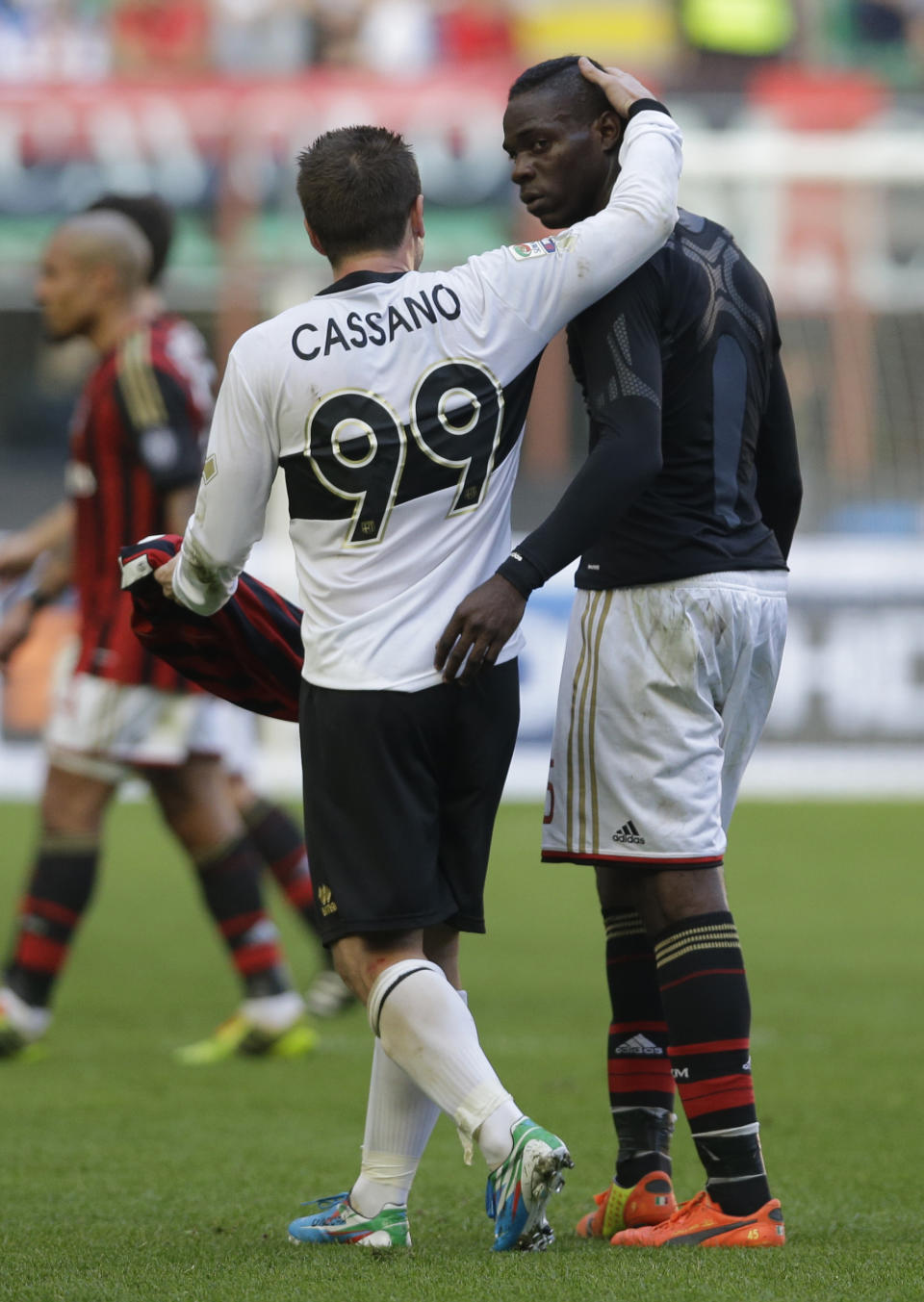 Parma forward Antonio Cassano, left, hugs AC Milan forward Mario Balotelli at the end of the first half time, during a Serie A soccer match between AC Milan and Parma, at the San Siro stadium in Milan, Italy, Sunday, March 16, 2014. (AP Photo/Luca Bruno)