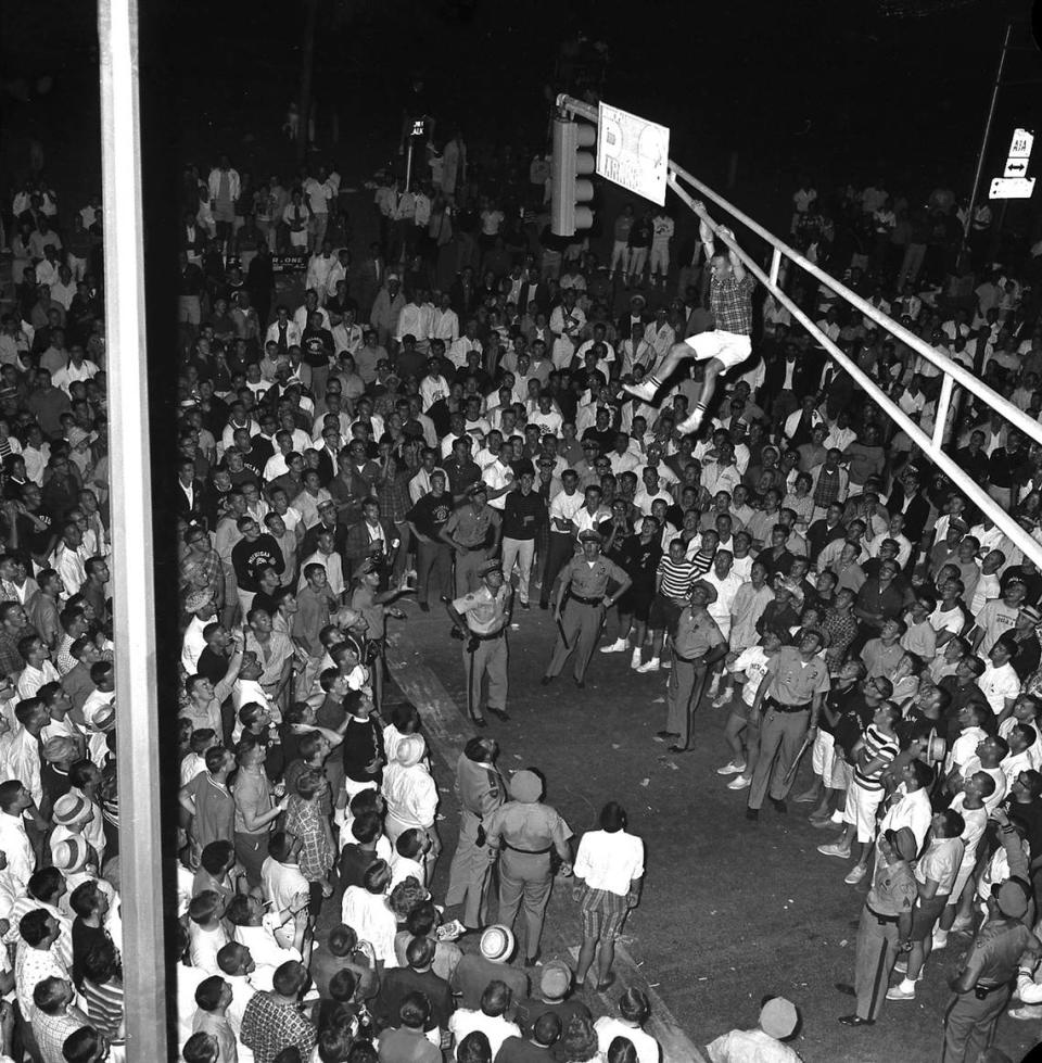 This 1961 spring break photo shows a student who climbed the light pole in front of the Elbo Room on Fort Lauderdale beach.