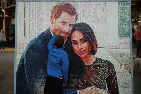 A boy touches a LEGO brick mosaic of Britain's Prince Harry and Meghan Markle in Windsor, Britain, May 18, 2018. REUTERS/Marko Djurica
