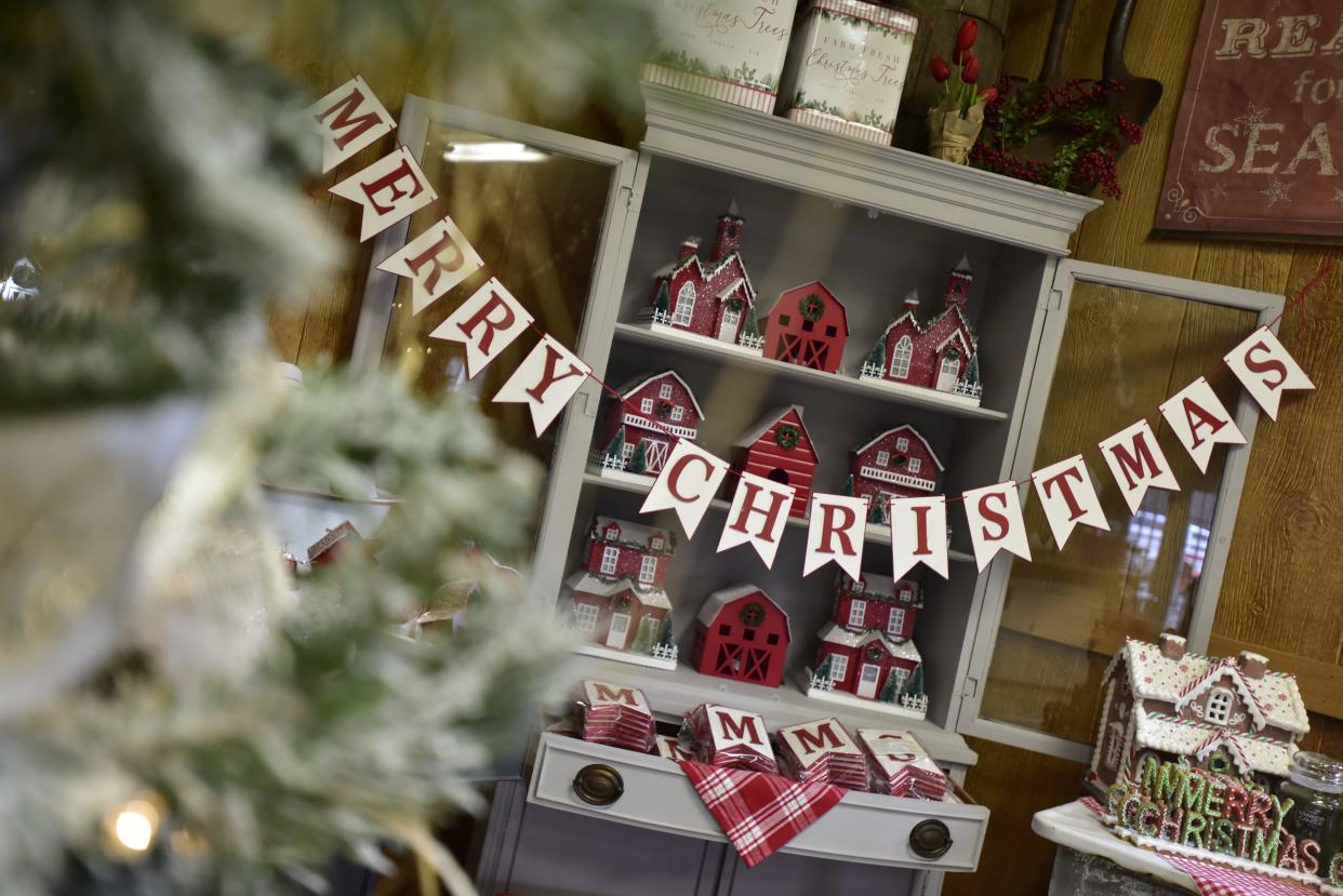 A Christmas banner hangs across the wall in front of decorations up for sale at Country Christmas Tree Farm located at 8122 Bricker Rd., in Avoca on Monday, Nov. 14, 2022. The farm’s country store sells wreathes, Christmas decorations and craft supplies. In addition to the country store and trees, customers can enjoy wagon rides and hot chocolate.