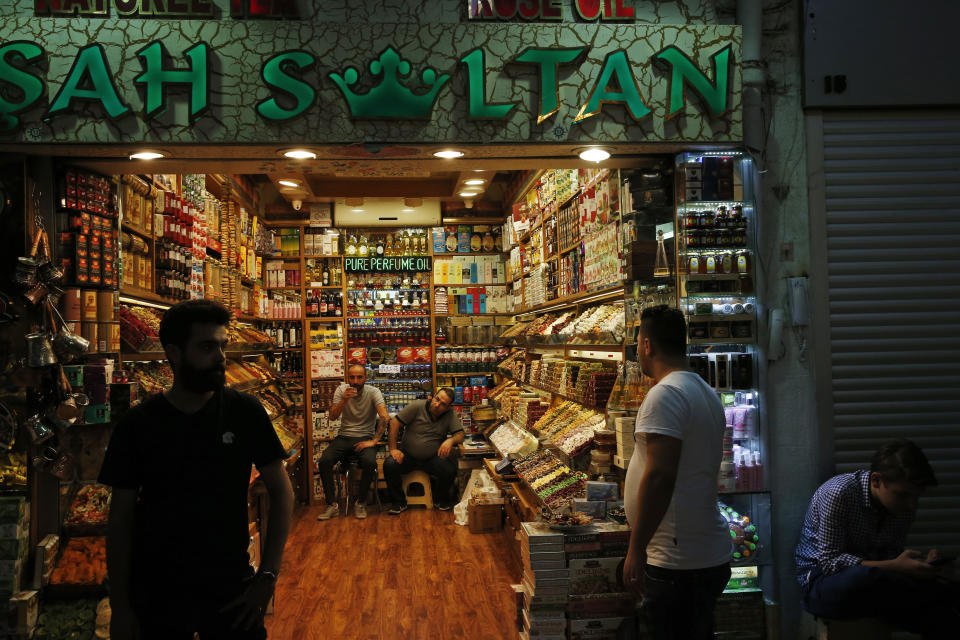 Shop owners wait for customers at Istanbul's Grand Bazaar, one of the city's main tourist attractions, Friday, Aug. 17, 2018. Turkey's lira currency fell once again, as Turkey and the United States exchanged new threats of sanctions Friday. (AP Photo/Lefteris Pitarakis)