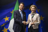 FILE - In this Wednesday, Sept. 11, 2019 file photo, European Commission President Ursula von der Leyen, right, shakes hands with Italian Prime Minister Giuseppe Conte prior to a meeting at the EU Charlemagne building in Brussels. When Giuseppe Conte exited the premier’s office, palace employees warmly applauded in him appreciation. But that’s hardly likely to be Conte’s last hurrah in politics. Just a few hours after the handover-ceremony to transfer power to Mario Draghi, the former European Central Bank chief now tasked with leading Italy in the pandemic, Conte dashed off a thank-you note to citizens that sounded more like an ’’arrivederci″ (see you again) then a retreat from the political world he was unexpectedly propelled into in 2018. (AP Photo/Francisco Seco, Pool)