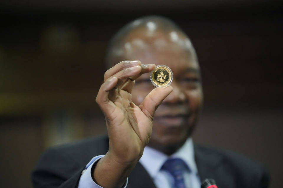 FILE - Reserve Bank of Zimbabwe Governor, John Mangudya holds a sample of a gold coin at the launch in Harare, on July 25, 2022. Zimbabwe will launch a digital currency next month by introducing “tokens” that are backed by gold reserves and can be transferred between people and businesses as a form of payment, the country's central bank said Friday April 28, 2023. (AP Photo/Tsvangirayi Mukwazhi, File)