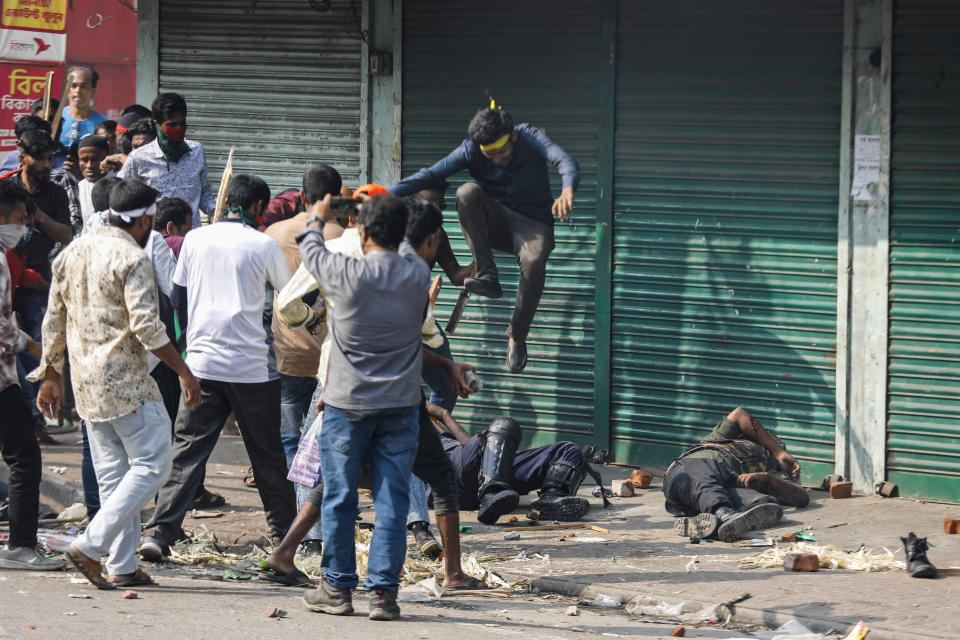 Activists of the Bangladesh Nationalist Party attack security officers during a protest in Dhaka, Bangladesh, Saturday, Oct. 28, 2023. Police in Bangladesh's capital fired tear gas to disperse supporters of the main opposition party who threw stones at security officials during a rally demanding the resignation of Prime Minister Sheikh Hasina and the transfer of power to a non-partisan caretaker government to oversee general elections next year. (AP Photo/Mahmud Hossain Opu)