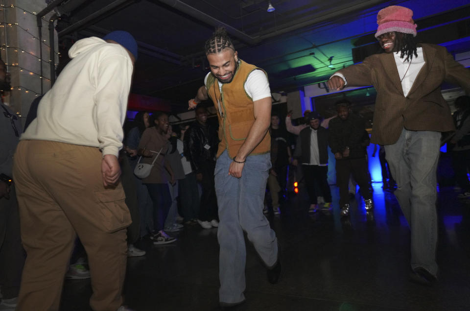 One of The Cove's seven co-founders, Aaron Dews, center, takes the spotlight in the center of the dance floor on Saturday, Feb. 17, 2024, in Nashville, Tenn. The Cove is an alcohol free, 18-and-up, pop-up Christian nightclub started by seven friends in their 20s who sought to build a thriving community and a welcoming space for Christian adults outside houses of worship. (AP Photo/Jessie Wardarski)