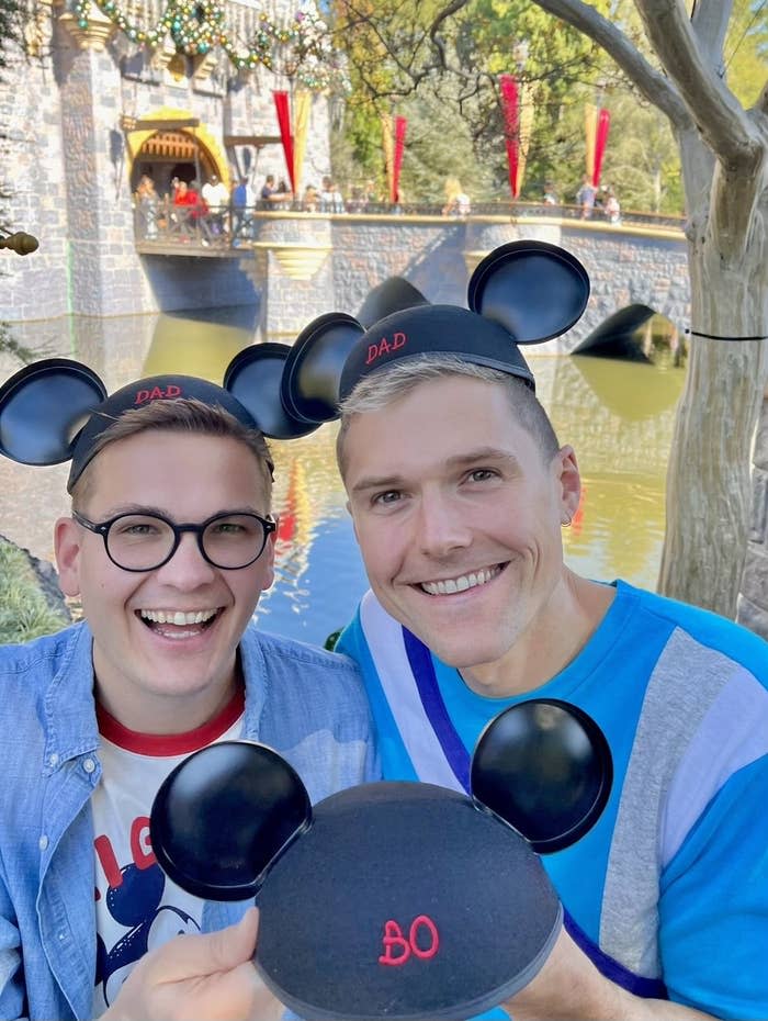 Kent Thomas (right) and his husband Mike (left) hold a hat for their soon-to-be-born child. 