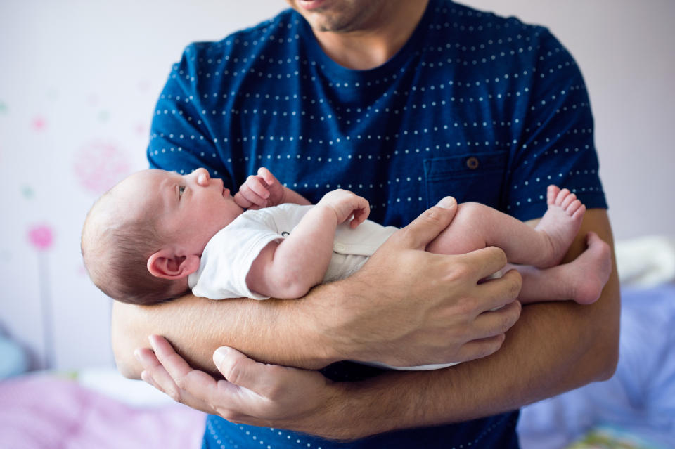 Man cradling infant in his arms