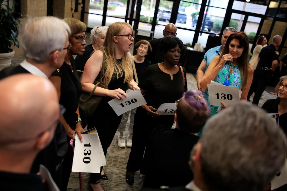 Members from the Interfaith Coalition for Action, Reconciliation and Empowerment congregate and cling to signs reading 130 that the group says is how many died in criminal homicides in 2022 in Jacksonville. ICARE members were among those who attended a town hall meeting hosted by Sheriff T.K. Waters.