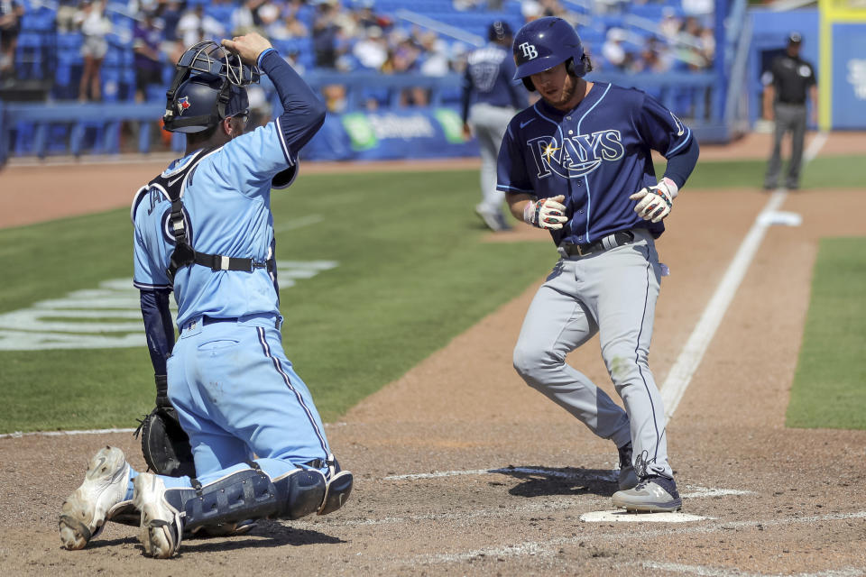 Tampa Bay Rays' Brett Phillips, right, scores on a walk to Manuel Margot in front of Toronto Blue Jays catcher Danny Jansen during the ninth inning of a baseball game Sunday, May 23, 2021, in Dunedin, Fla. (AP Photo/Mike Carlson)