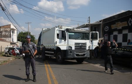 A police officer is seen near a site where an armed gang holds people hostage after they robbed a securities company at the Viracopos airpoart freight terminal, in Campinas