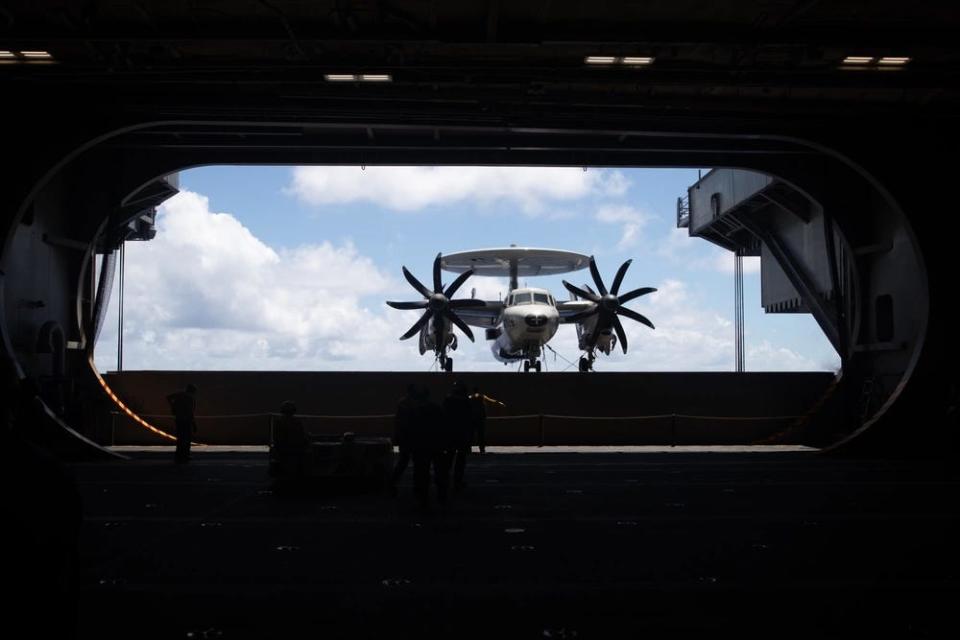 An E-2C Hawkeye descends on an aircraft elevator on the Nimitz-class aircraft carrier USS George Washington (CVN 73)