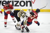 Boston Bruins defenseman Andrew Peeke (52) collides with Florida Panthers center Kevin Stenlund (82) and right wing Kyle Okposo (8) during the first period of Game 5 of the second-round series of the Stanley Cup Playoffs, Tuesday, May 14, 2024, in Sunrise, Fla. (AP Photo/Wilfredo Lee)