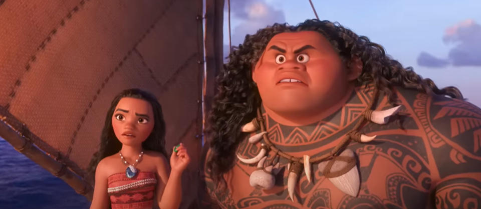 Moana and Maui stand on a boat in the ocean, looking ahead. Moana wears a red dress with tribal patterns, and Maui has long curly hair and tribal tattoos