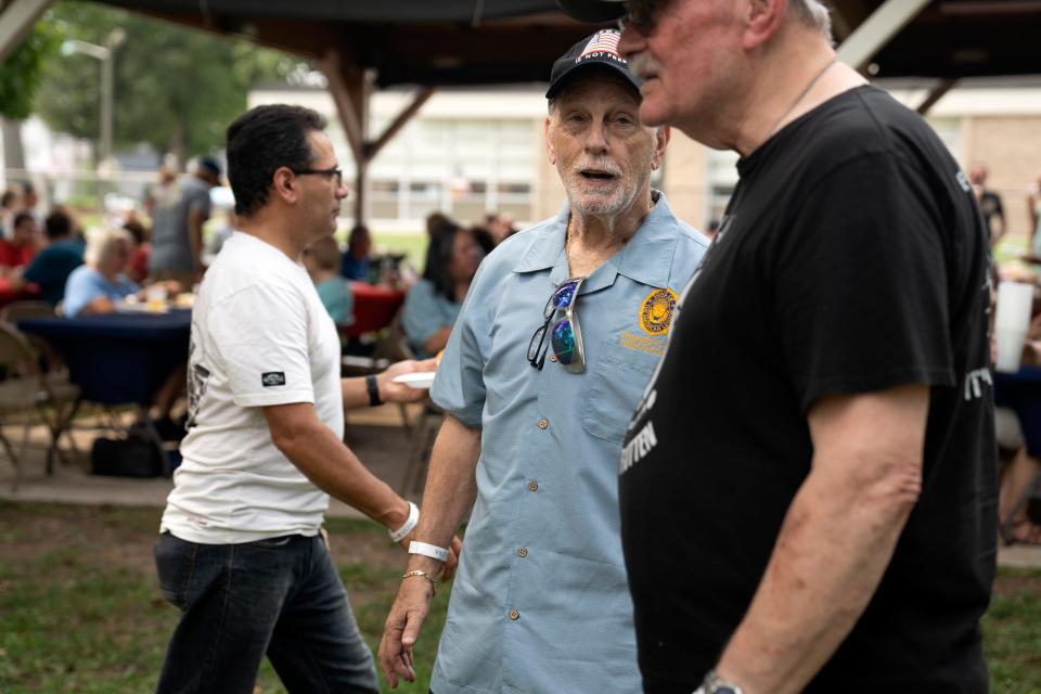 Forrest Elliott talks with Richard Palka as he (Elliott) volunteers at American Legion Post 310 in Little Ferry during their annual pig roast to raise money for veterans on Saturday, July 15, 2023. Elliott, a retired middle school teacher, has devoted his life to helping others.