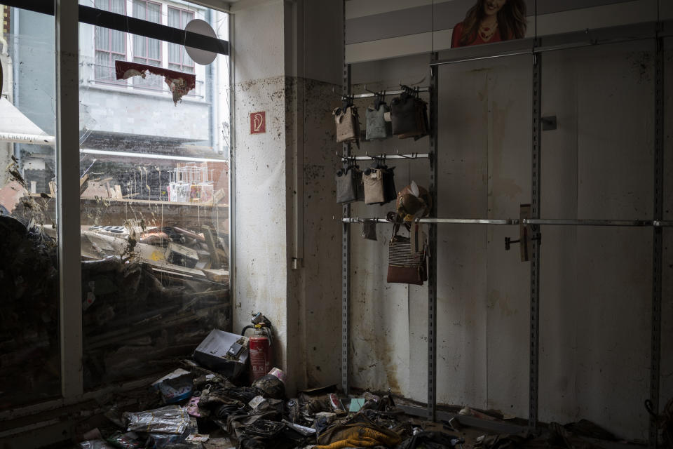 Handbags hang in a destroyed clothing store in Bad Neuenahr-Ahrweiler, Germany, Monday July 19, 2021. More than 180 people died when heavy rainfall turned tiny streams into raging torrents across parts of western Germany and Belgium, and officials put the death toll in Ahrweiler county alone at 110. (AP Photo/Bram Janssen)