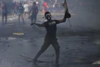 A member of the Inter University Students Federation throws fired tear gas canister back to police during an anti government protest in Colombo, Sri Lanka, Thursday, May 19, 2022. Sri Lankans have been protesting for more than a month demanding the resignation of President Gotabaya Rajapaksa, holding him responsible for the country's worst economic crisis in recent memory. (AP Photo/Eranga Jayawardena)