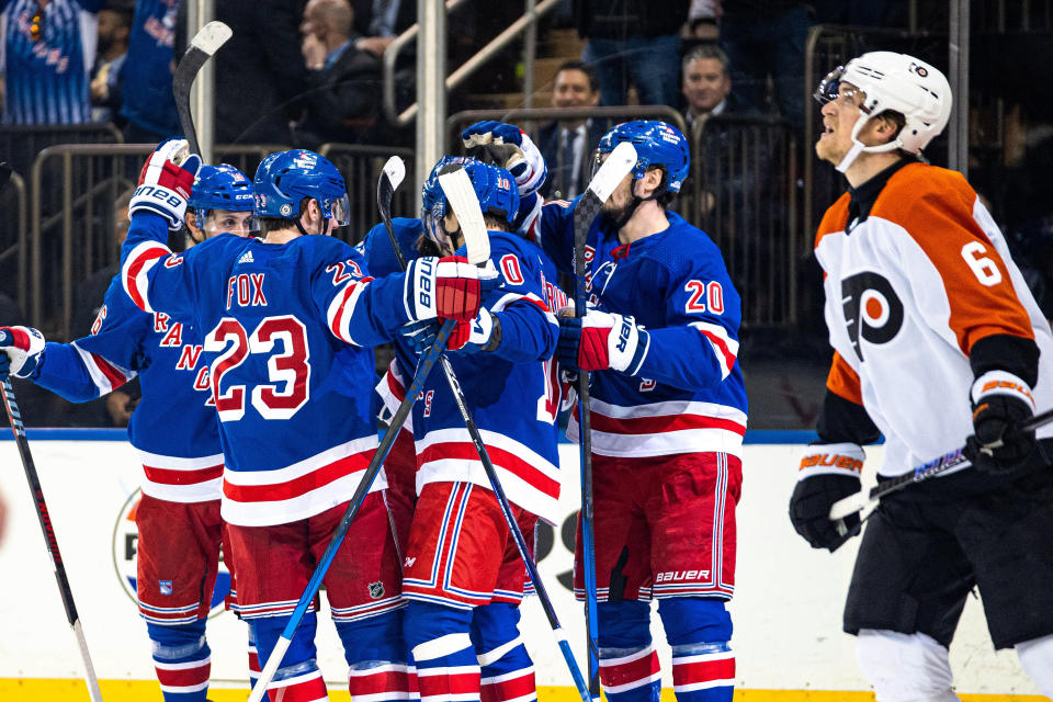 New York Rangers celebrate a goal by Mika Zibanejad, obscured at center, as Philadelphia Flyers' Travis Sanheim (6) looks at the scoreboard during the second period of an NHL hockey game Tuesday, March 26, 2024 in New York. (AP Photo/Peter K. Afriyie)