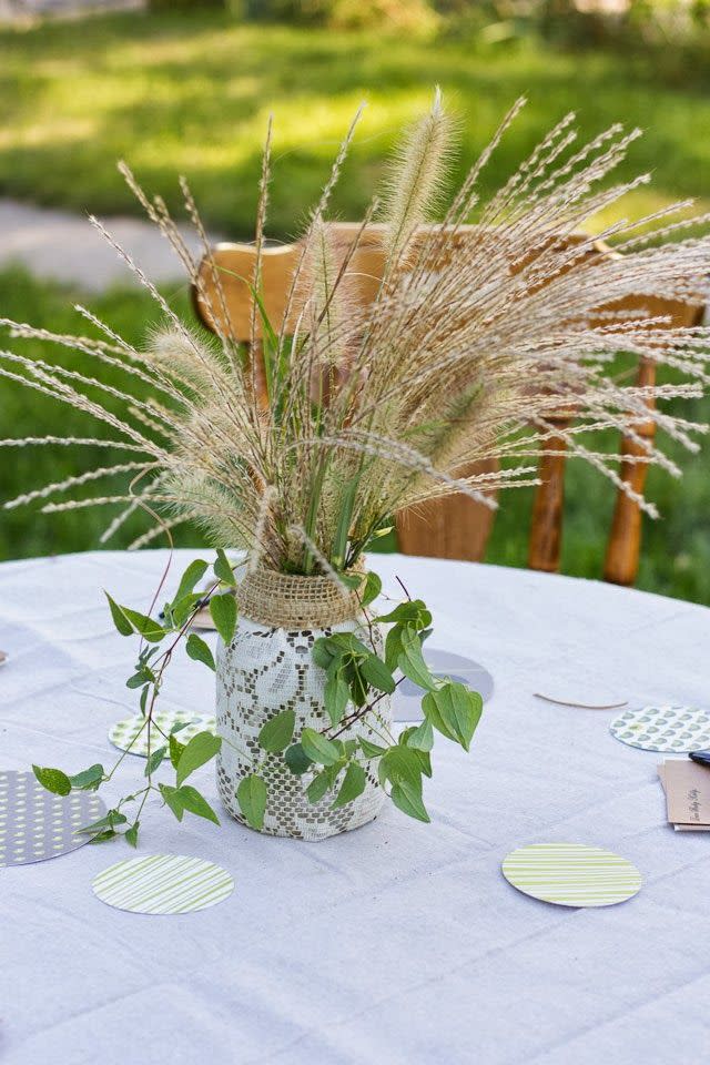 a great idea for a baby shower, this centerpiece is made with lace wrapped around a mason jar and