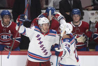 Montreal Canadiens look on as New York Rangers' Kevin Rooney (17) and Chris Kreider (20) celebrate an empty-net goal during the third period of an NHL hockey game Saturday, Oct. 16, 2021, in Montreal. (Graham Hughes/The Canadian Press via AP)