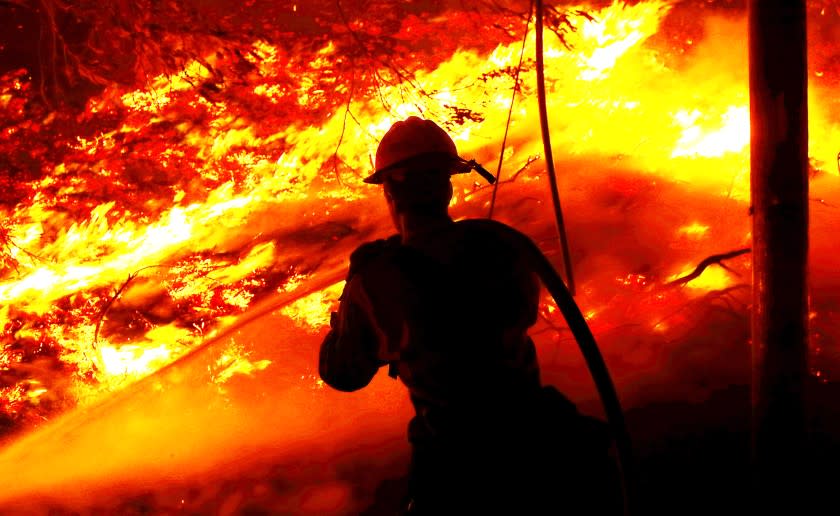 A firefighter battles the Alisal fire along the 101 Freeway near Goleta on Tuesday, Oct. 12, 2021.