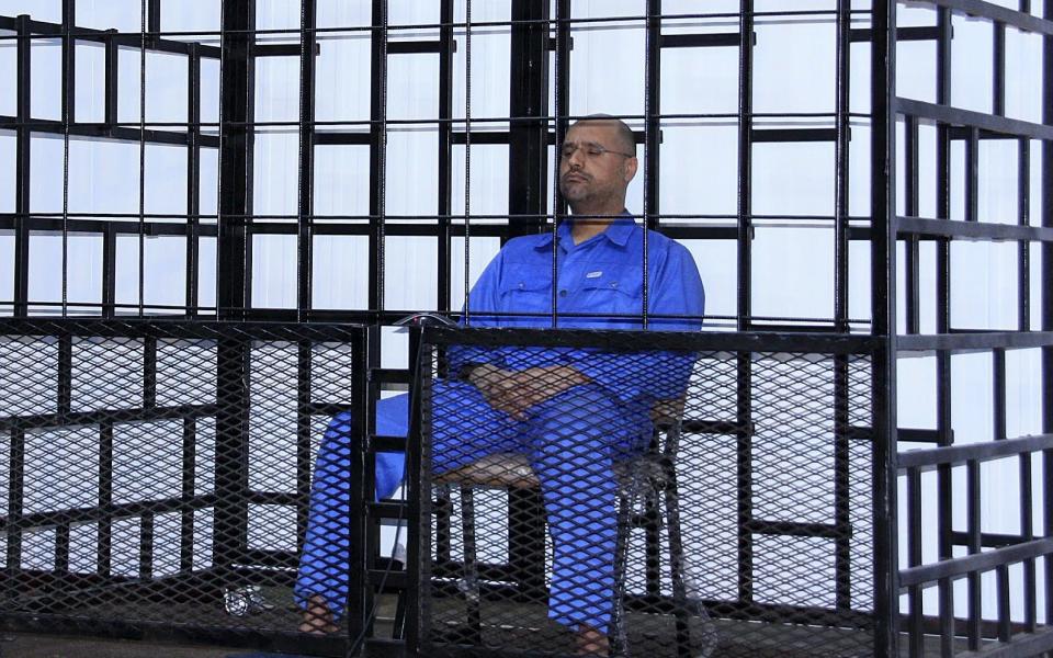 Saif al-Islam Gaddafi, attends a hearing behind bars in a courtroom in Zintan, Libya in May 25, 2014 - Reuters 