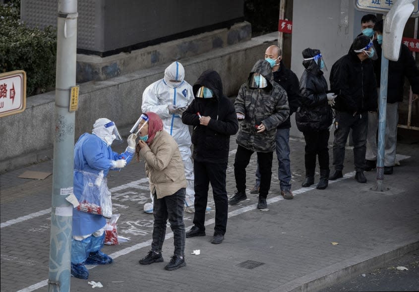 Officials test pedestrians in China for COVID-19. 