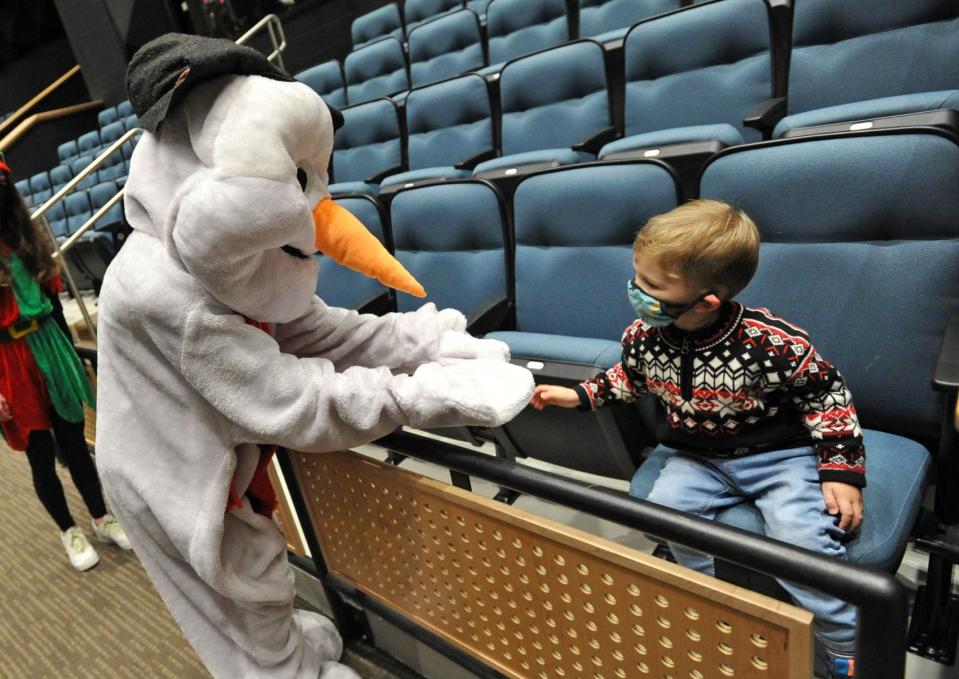 Frosty the Snowman greets William Yates, 3, of Scituate, during the Scituate North Pole Express Movie Experience presented by the Community of Resources for Special Education Foundation at the Scituate Center for Performing Arts on Saturday, Dec. 4, 2021.