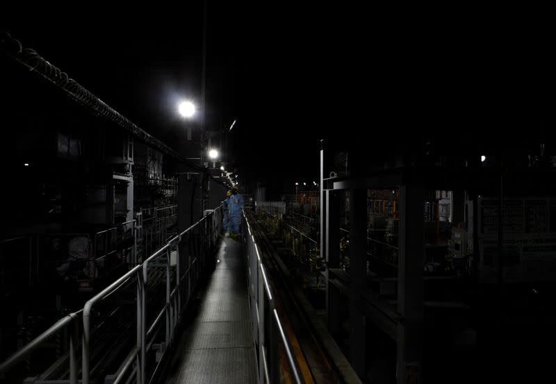 Employees of TEPCO wearing are seen inside a facility known as ALPS that removes radioactive materials from water used to cool damaged reactors at tsunami-crippled Fukushima Daiichi nuclear power plant in Okuma town, Japan