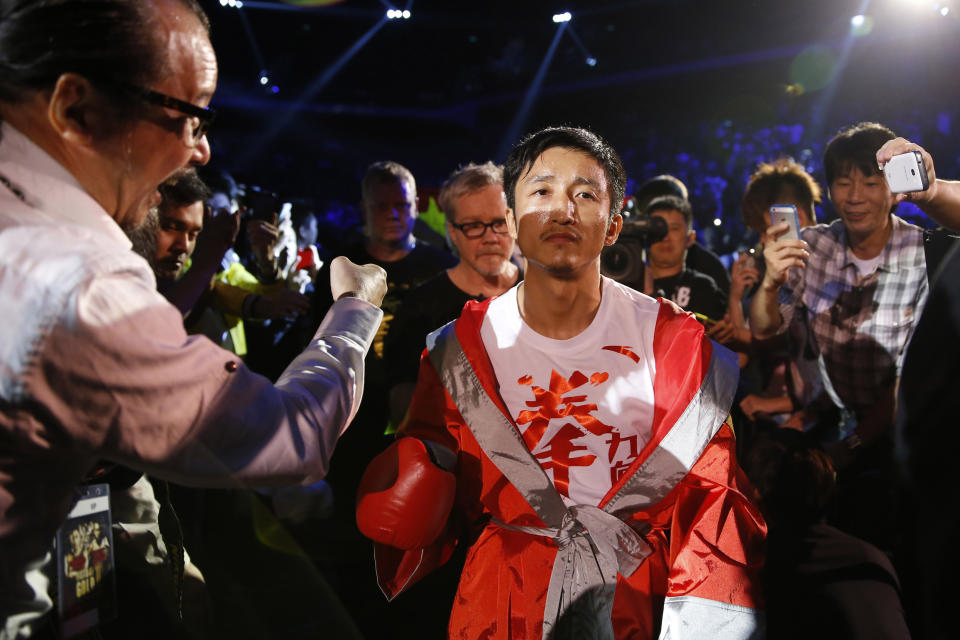 In this July 27, 2013 photo, Chinese boxer Zou Shiming, center, is greeted by his fans before the Flyweight Bout match against Mexico's Jesus Ortega at the Cotai Arena in Venetian Macao in Macau. The Chinese fighter’s victory at a Macau showdown brings the world’s top casino market a step closer to challenging Las Vegas for dominance of another Sin City staple: big-time boxing matches. Macau, which long ago eclipsed Vegas as the world's top gambling city, is now looking to add to its allure by holding the kind of boxing bouts that Las Vegas is known for. (AP Photo/Dennis Ho)