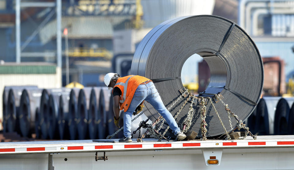 In this July 25, 2018, photo a truck driver chains down a roll of steel to his flatbed at the NUCOR Steel Gallatin plant in Ghent, Ky. The rolls, weighing as much as 20 tons, are transported one at a time. On Wednesday, Aug. 15, the Federal Reserve reports on U.S. industrial production for July. (AP Photo/Timothy D. Easley)