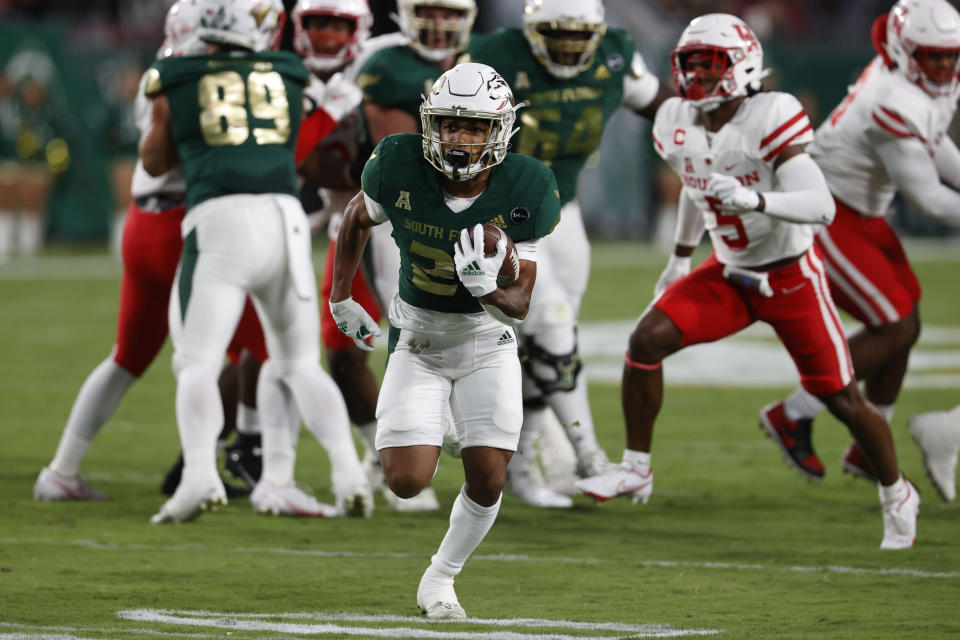 CORRECTS TO BRIAN BATTIE, INSTEAD OF K'WAN POWELL - South Florida running back Brian Battie (21) heads to the end zone for a touchdown against Houston during the first half of an NCAA college football game Saturday, Nov. 6, 2021, in Tampa, Fla. (AP Photo/Scott Audette)