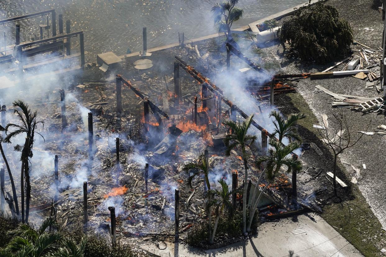 Smoldering homes are seen in the aftermath of Hurricane Ian, Thursday, Sept. 29, 2022, in Fort Myers Fla.