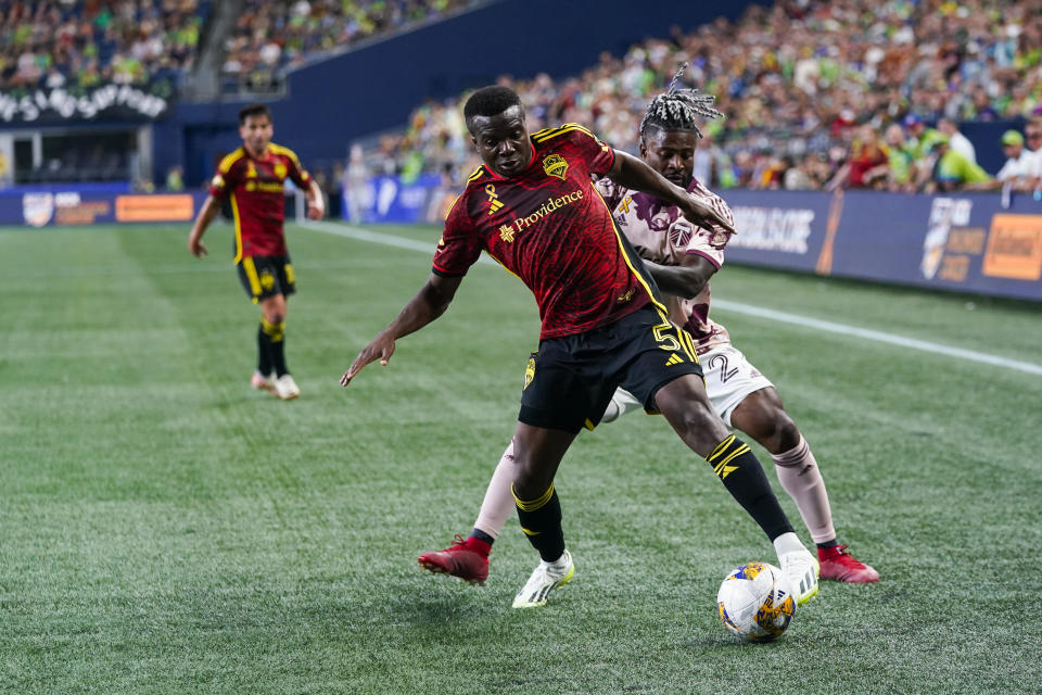 Seattle Sounders defender Nouhou Tolo (5) tries to keep possession against Portland Timbers forward Dairon Asprilla during the second half of an MLS soccer match Saturday, Sept. 2, 2023, in Seattle. The teams played to a 2-2 draw. (AP Photo/Lindsey Wasson)