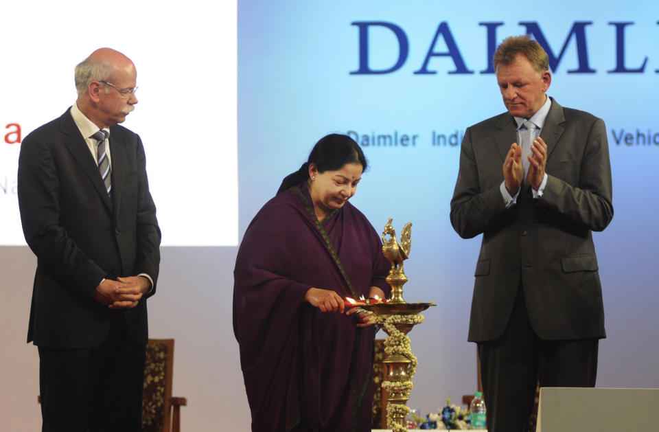 Daimler AG Chief Executive Dieter Zetsche, left, watches Daimler management board member Andreas Renschler, right, applauds as Tamil Nadu State Chief Minister J. Jayalalitha lights a traditional lamp during the opening ceremony of the Daimler's new factory in Oragadam at Kancheepuram district, 60 kilometers (38 miles) from Chennai, India, Wednesday, April 18, 2012. The German auto maker will start building trucks at the new factory beginning in the third quarter. The factory will initially have a capacity to make 36,000 trucks a year and raise it to 72,000 units, the company said. (AP Photo/Arun Shankar)