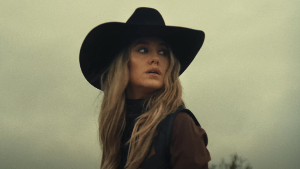 Lainey wilson in black hat in music video for "Wild Flowers and Wild Horses". 