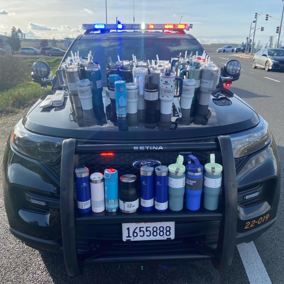 A bunch of Stanley cups on a police car